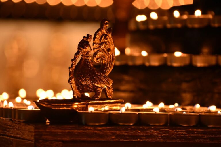 Close-up of beautifully lit Diwali diyas surrounded by marigold flowers and decorative candles on a festive table