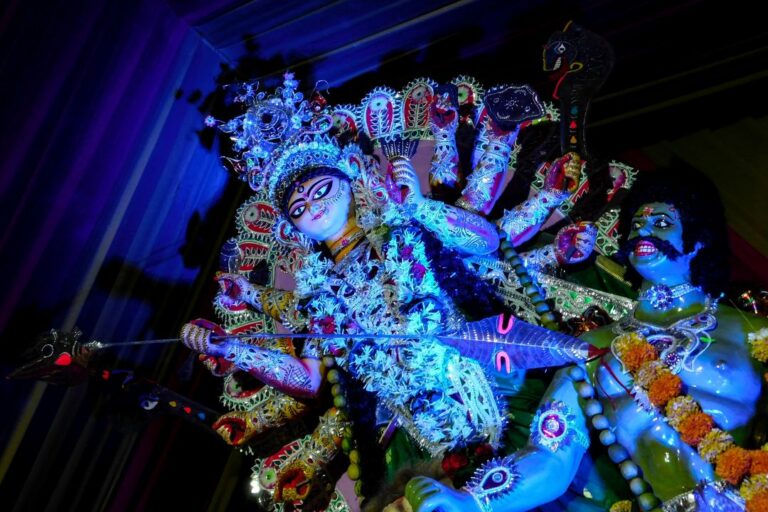 The Durga Maa temple beautifully lit up during Navratri, with devotees offering prayers and the vibrant atmosphere filled with festive decorations.