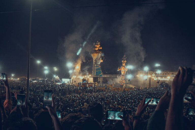 A dramatic scene of Ravana’s effigy burning during Dussehra celebrations, with fireworks lighting up the sky and crowds cheering.