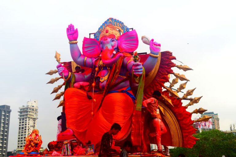 A colorful and vibrant Ganesh Chaturthi celebration with a richly adorned Lord Ganesha idol, surrounded by bright flowers, rangoli, and decorative lights