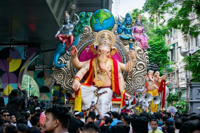 The lively scene of a Ganesh Chaturthi procession, with people dancing and celebrating as the idol of Lord Ganesha is carried through the streets.