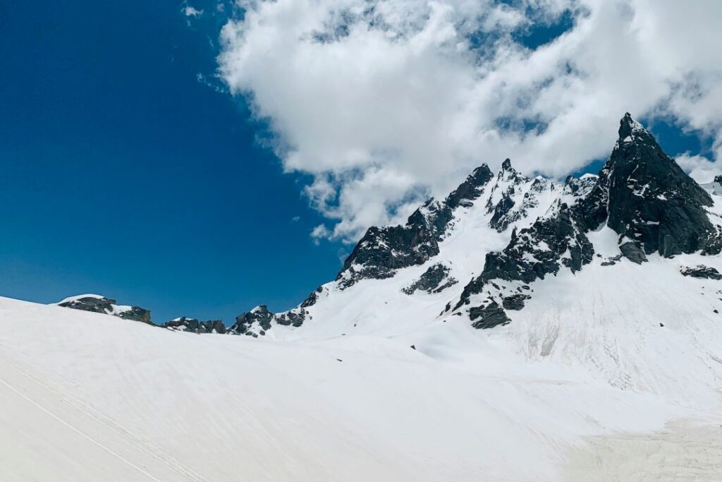 A stunning view of the Hampta Pass Trek, featuring snow-capped mountains.