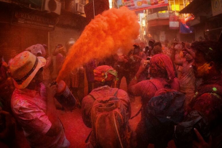 A vibrant Holi celebration with colorful powders in the air, as people laugh and enjoy the festive atmosphere.