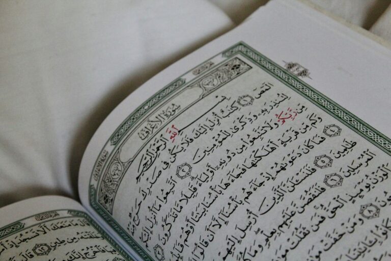 A close-up of the Quran opened to a page, showcasing intricate Arabic calligraphy and beautiful detailing on its pages